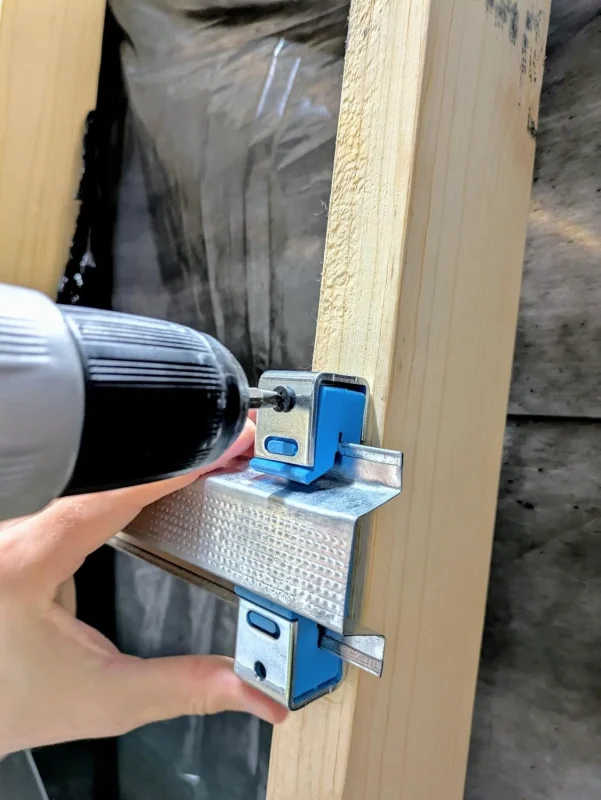 screwing resiliant channel into 2x4 for soundproofing drums